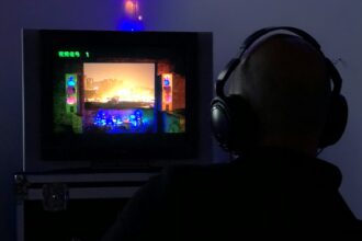 a man sitting in front of a tv with headphones on